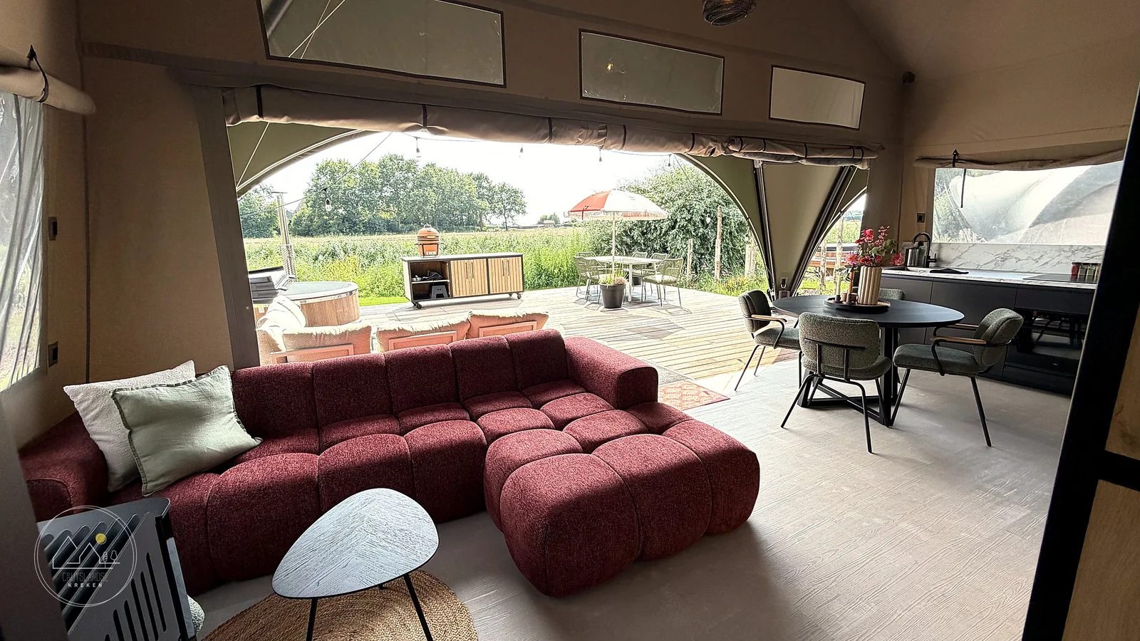 Woonkamer met uitzicht op het terras van De Grutto Lodge